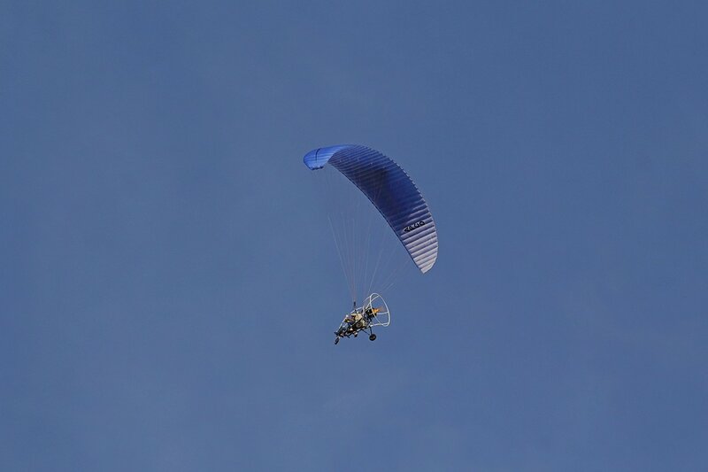 Паралёт (аэрошют, мотопараплан со специальной тележкой) в небе над Кировом. Параплан (парашют-крыло) с двигательной установкой с пропеллером