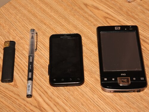 Слева направо: зажигалка, ручка, Motorola Defy+, 4-дюймовый HP 214