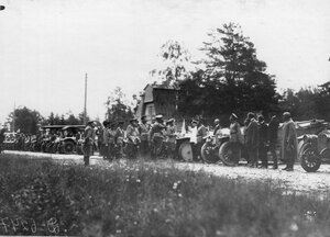 Император Николай II и сопровождающие его лица обходят колонну автомобилей.