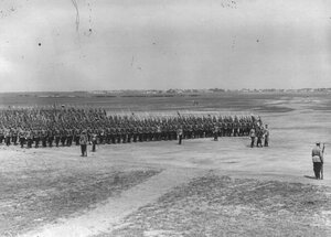 Войска лагерного сбора проходят церемониальным маршем по военному полю.