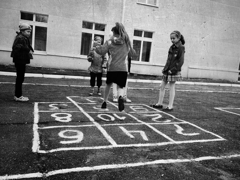 Девчонки играют в прыгалки на школьном дворе