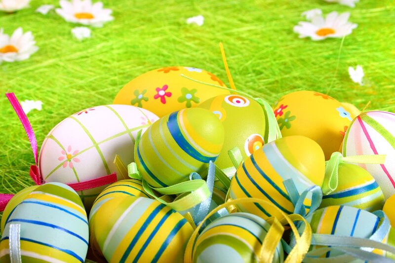 closeup of several easter eggs over green grass.