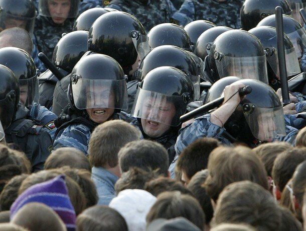 Russian riot police scuffle with protesters during the 