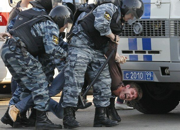 Russian riot police detain a protester during the 