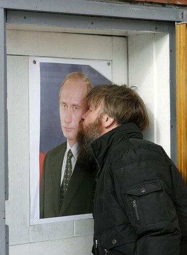 A man kisses a portrait of Russia's Prime Minister Vladimir Putin at the entrance of his garage in Russia's Siberian city of Krasnoyarsk