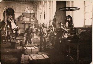 Механики и солдаты авиароты за работой в сборочной мастерской.