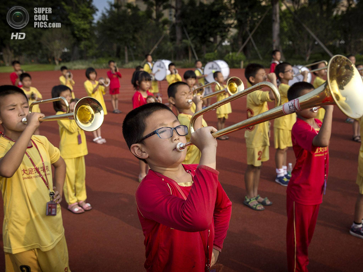 Китай. Цинъюань, Гуандун. 13 июня. Школьный оркестр. (Kevin Frayer/Getty Images)