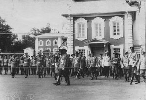 Император Николай ii и цесаревич Алексей в сопровождении свиты и командира полка обходят полк, выстроившийся для парада.