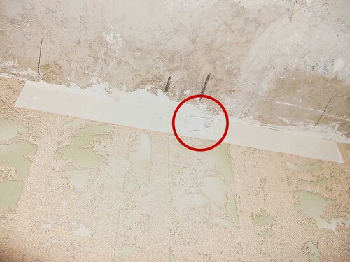 Фото 9. Диагностическое вскрытие стены. Первый ракурс. В тёмно-красном круге видна выборка материала стены.