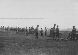 Группа солдат в поле у орудия.