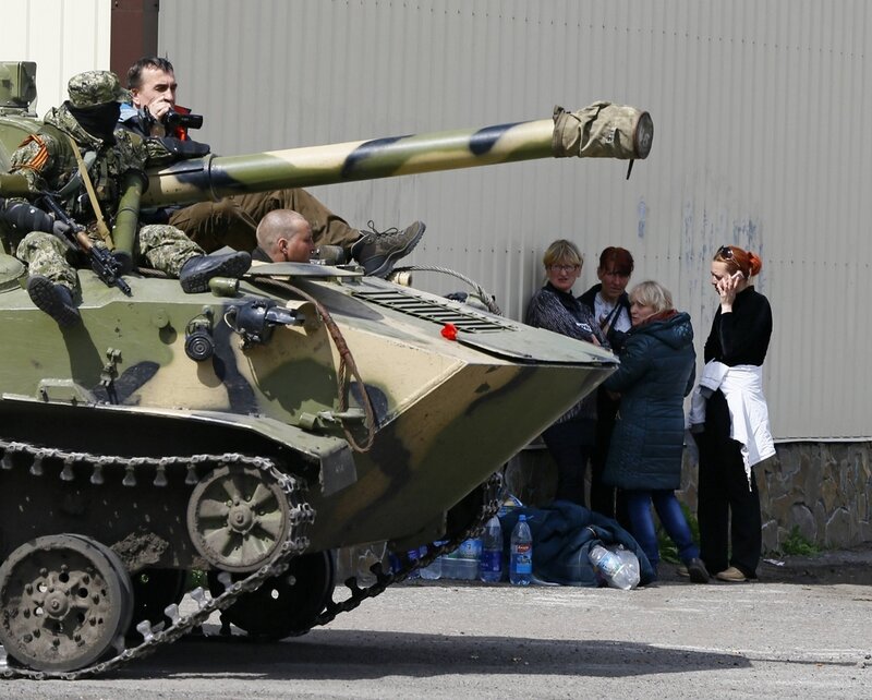 А тем временем на юго-западе Украины... People stand near armed men on an armoured personnel carrier in Slaviansk
