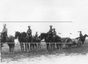 Офицер с группой солдат в поле у орудийных повозок.