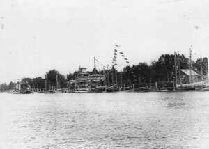  Яхты  клуба, выстроившиеся вдоль берега  Средней Невки и украшенные флагами по случаю 50-летнего юбилея клуба