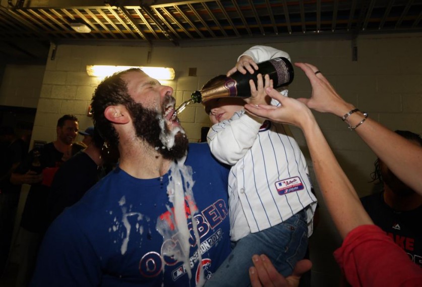 Джейк Арриета празднует победу над Питтсбургом в плей-офф (бейсбол) вместе со своим сыном Купером. (