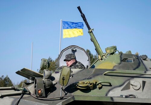 A Ukrainian soldier rides on an armoured personnel carrier during a military exercise near the village of Goncharivske