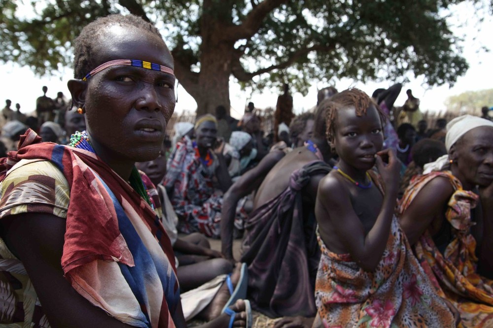 Women wait for food distribution in Gumu