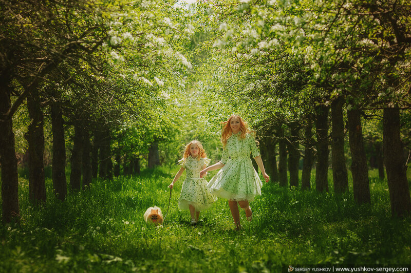 Мама и дочь в одинаковых платьях в цветущем саду