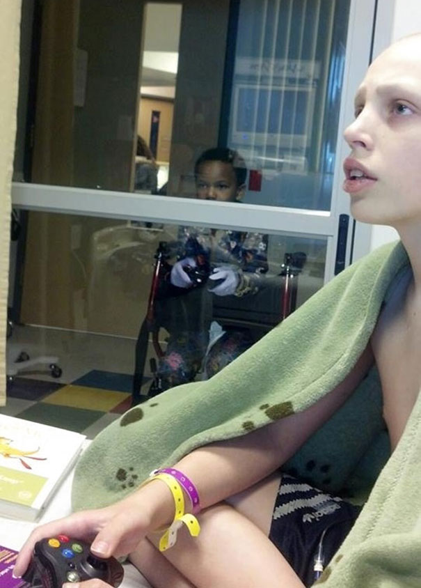 Мальчик играет в видеоигры в больнице со своим другом, который находится на карантине.