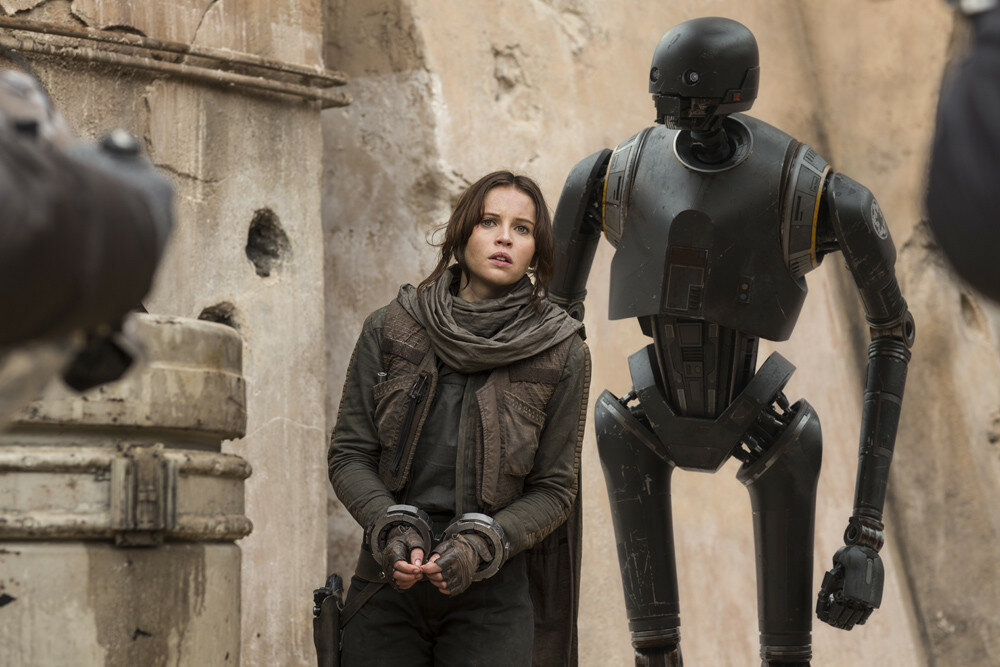 Rogue One: A Star Wars Story..L to R: Felicity Jones (Jyn Erso), and K-2SO (Alan Tudyk)..Ph: Jonathan Olley..© 2016 Lucasfilm Ltd. All Rights Reserved.